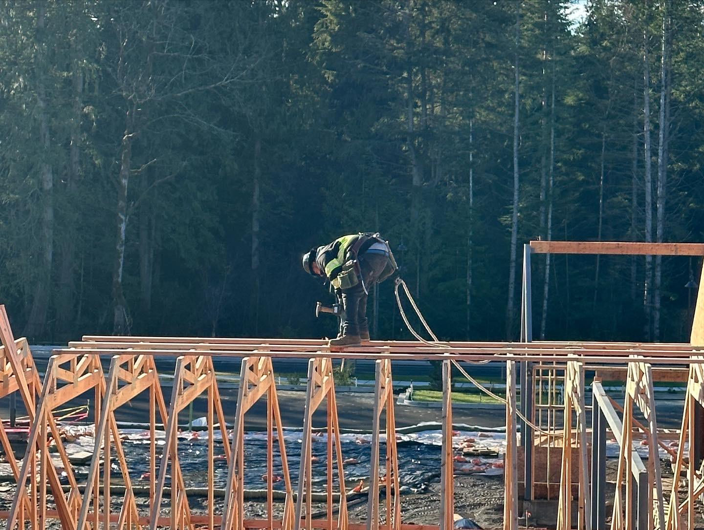 Framer working on engineered floor joists at golden hour on a Seattle-area jobsite