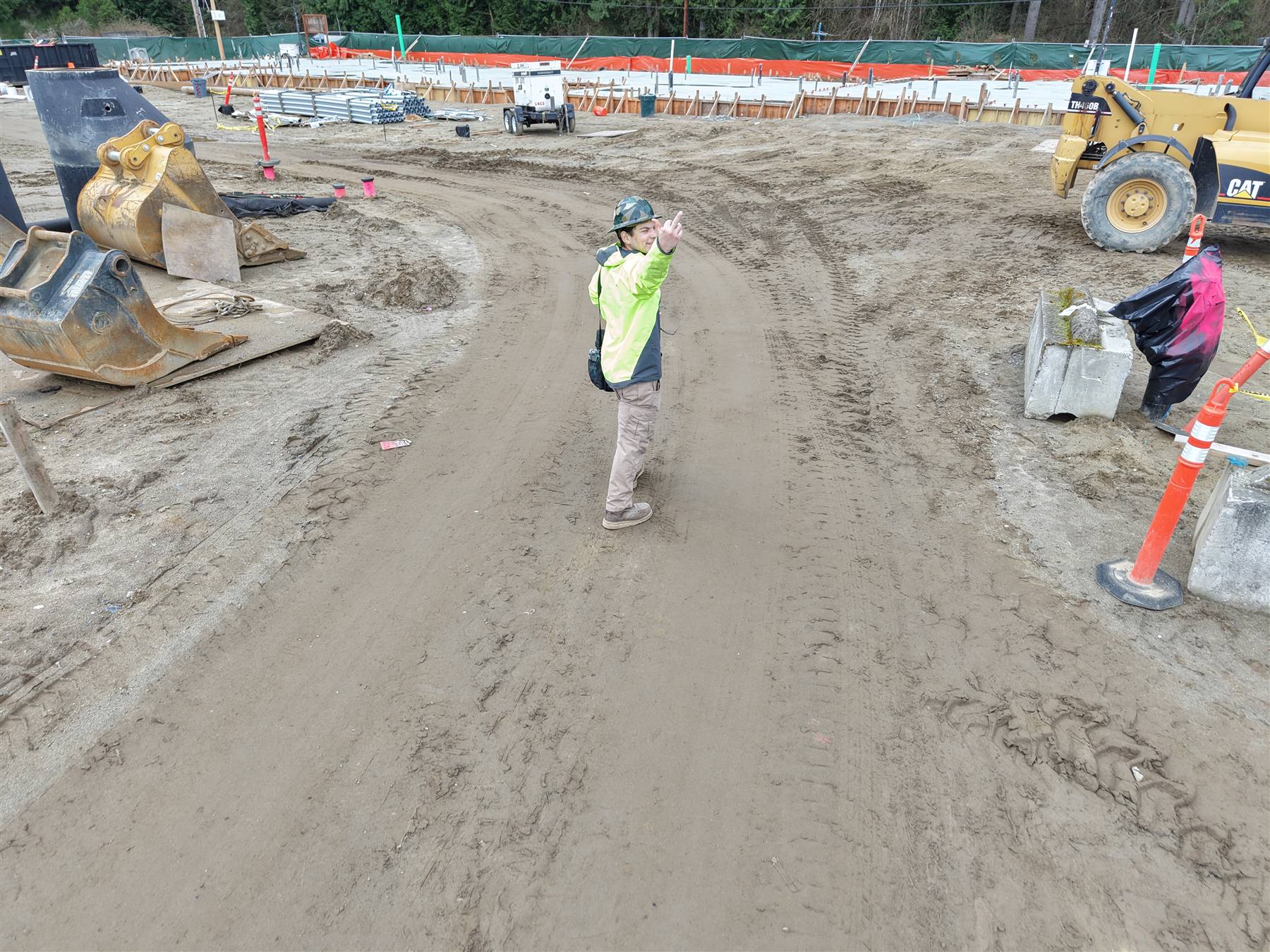TBG foreman directing layout on a graded multifamily building pad before framing